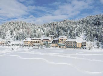 Das romantische Familienhotel direkt am Bergsee, im Winter absolut schneesicher, im Sommer angenehm fresh an der Grenze zwischen Steiermark und Kärnten. Schifahren, Snowboarden, Schneeschuhwandern, Eislaufen, Langlaufen im Winter, Wandern, Mountainbiken, Jagd und Entspannung im Sommer. Yoga, Retreats, Wellness, Spa, Seminar und Hochzeit mitten im Zirbenwald mit Bali Flair. Bio regionale Kulinarik, gerne auch vegan und vegetarisch. Panorama (c) Seehotel Jägerwirt - Blendpunkt