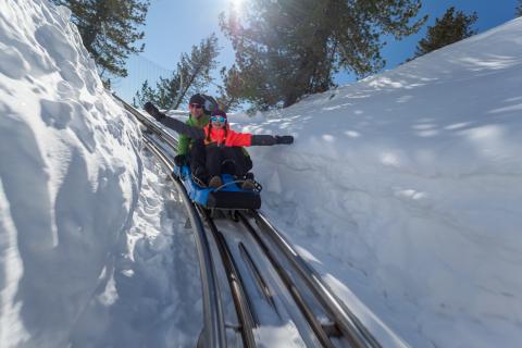 Abfahrt mit dem Nocky Flitzer im Schnee. An den Seiten ist der Schnee über einen Meter hoch. 