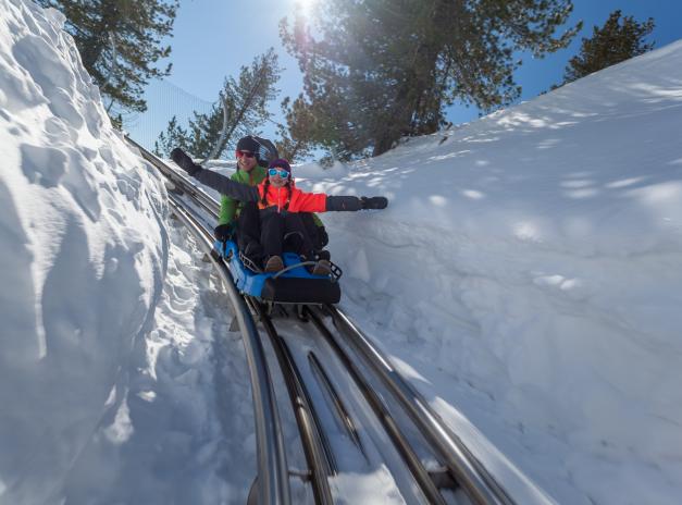 Abfahrt mit dem Nocky Flitzer im Schnee. An den Seiten ist der Schnee über einen Meter hoch. Nocky Flitzer im Schnee